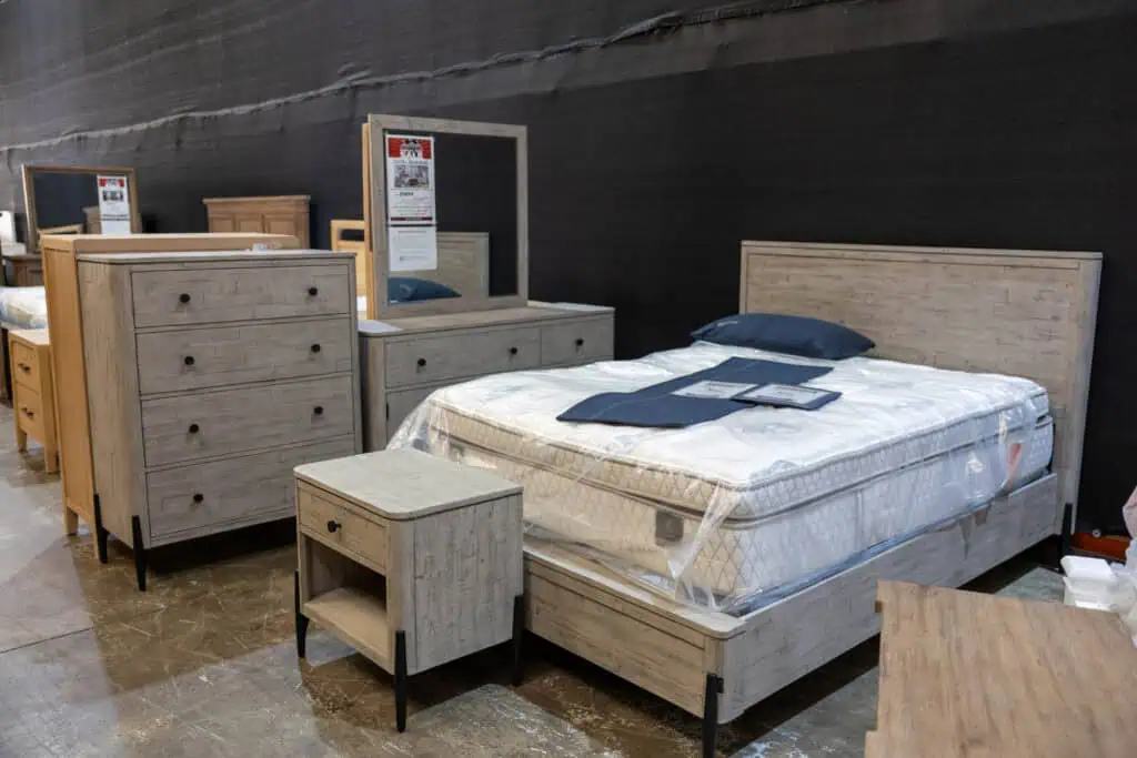 Bedroom furniture display with bed, dresser, mirror, and nightstand in a store.