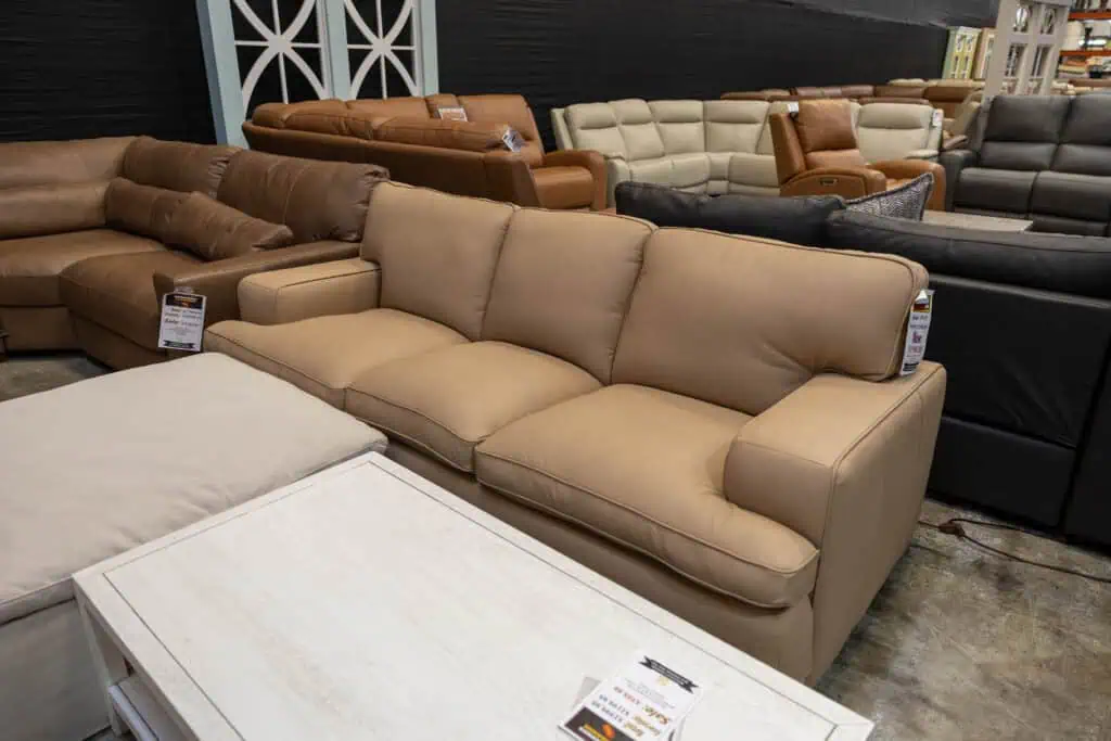 Various sofas displayed in a furniture store, including beige, brown, and black options.