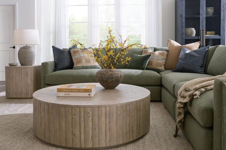 green performance fabric sectional with throw pillows, blanket, and centered coffee table