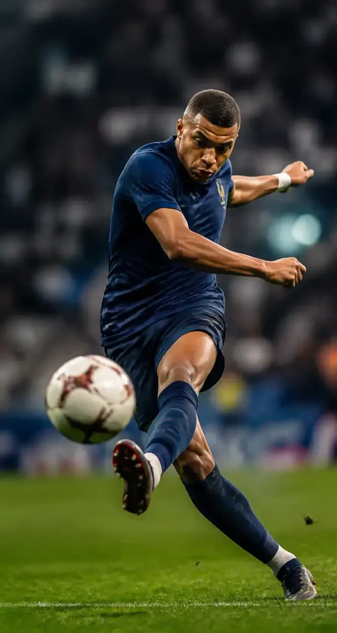 Joueur de football professionnel frappant le ballon dans un stade