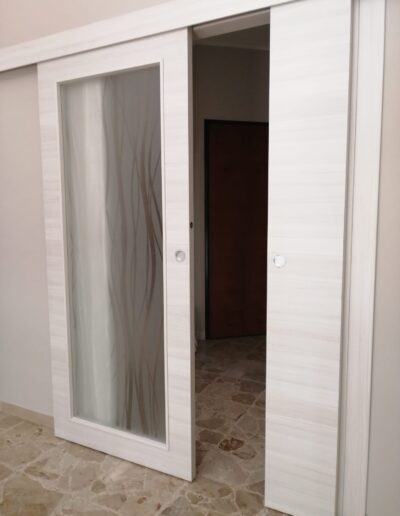 Serramento scorrevole in legno e vetro per interni, stile moderno e funzionale.