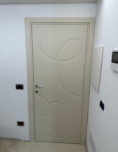 Finestra in alluminio beige con motivo decorativo a cerchi.