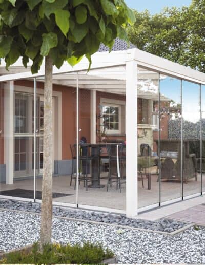 Vetrata scorrevole in alluminio e vetro per gazebo esterno con patio integrato.