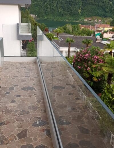 Balcone con ringhiera in vetro panoramico rispetto alla montagna naturale.