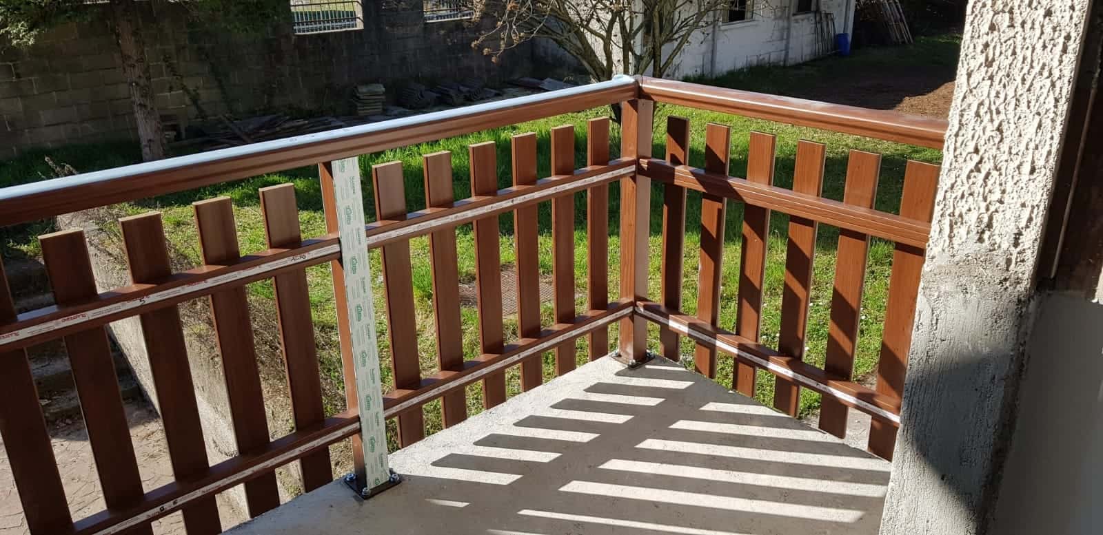 Bariera in legno per balcone con ringhiera, installata all'aperto, in un ambiente residenziale.