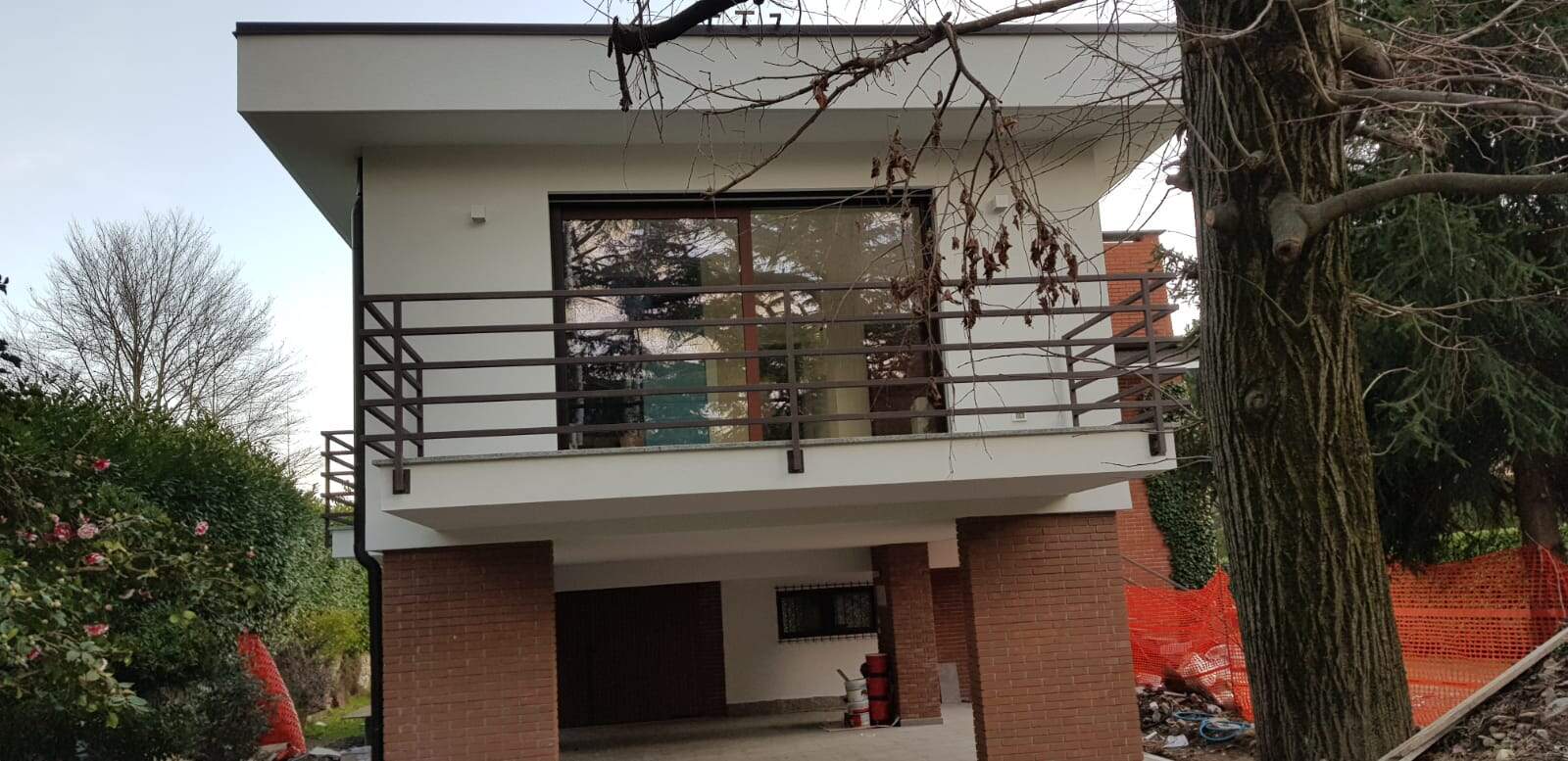 Finestra moderna con infissi in legno e balcone in ferro battuto.