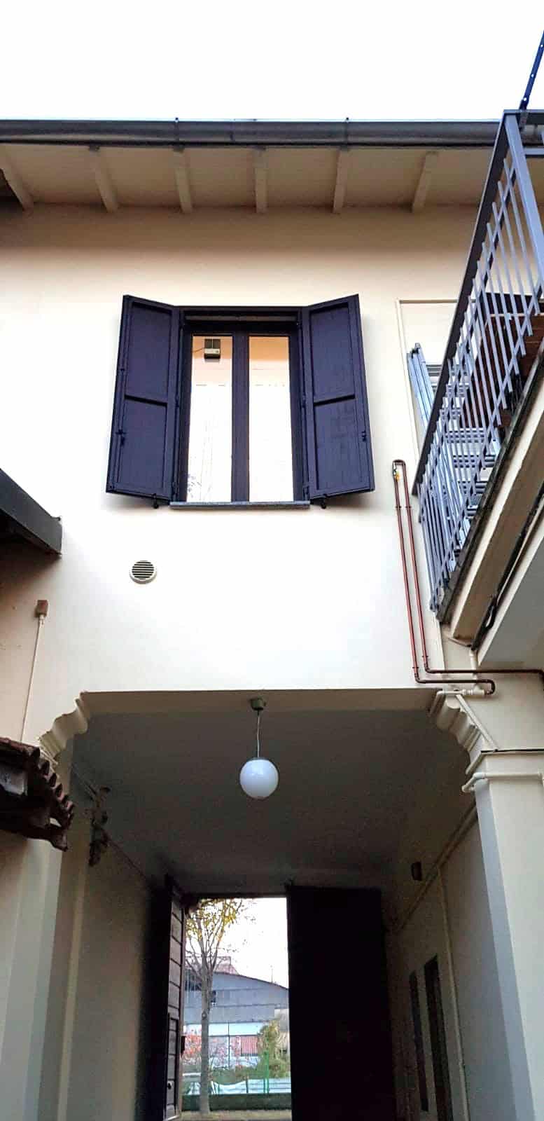 Serramento con persiana in ferro battuto nero, apertura a battente, ideale per abitazioni eleganti e sicure.