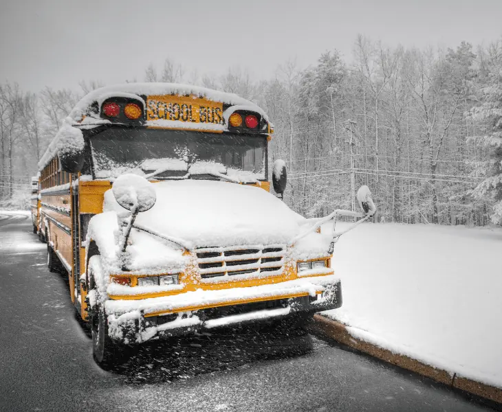 high winds cause snow to cover bus