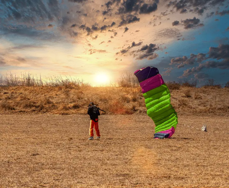sunset and skydiver with multicolor parachute