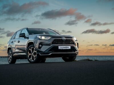 Toyota RAV4 Plug-in Hybrid på strandvej ved solnedgang.