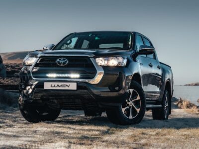 Sort Toyota Hilux SR 2021+ på motorvejen med et klart frontdesign.