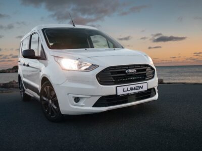 Hvid Ford Transit Connect 2018-2024 på vejen ved solnedgang.