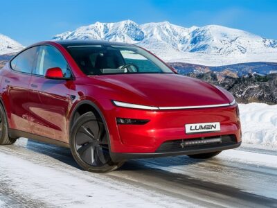 Tesla Model Y in snowy landscape with snow-covered mountains in the background.