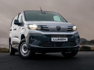 Peugeot Partner Lumen 2024+ i grå på en åben landevej.
