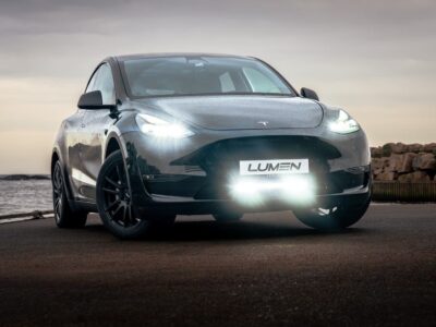 Tesla Model Y 2021-2023 with Lumen grill kit, black, near the sea.