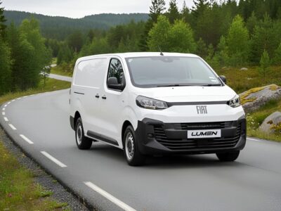 Hvid Fiat Lumen varevogn på landevej i skovområde.