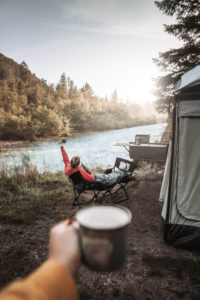 Off-road camping with family near river.