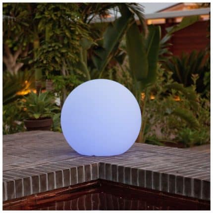 Solar-powered rechargeable light glowing on outdoor table at dusk.