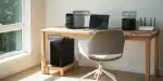 Portable power station setup with laptop, NAS, PC, and Wi-Fi router on a wooden desk.