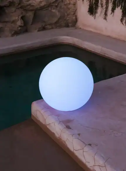 Floating Buly 40 Solar light on poolside for outdoor ambiance.