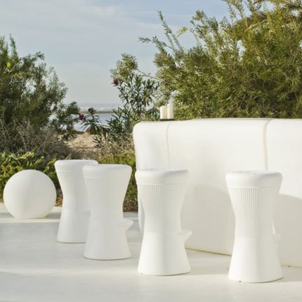 Modern white outdoor furniture with solar-powered lighting in a garden setting.