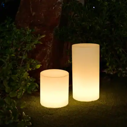 Two glowing solar lanterns on grass at night, outdoor lighting decor.