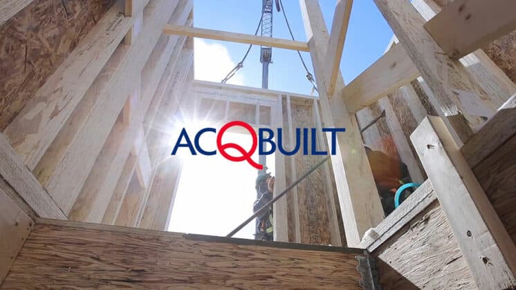 Brightly lit construction site with wooden framing and a crane overhead, showcasing building process.