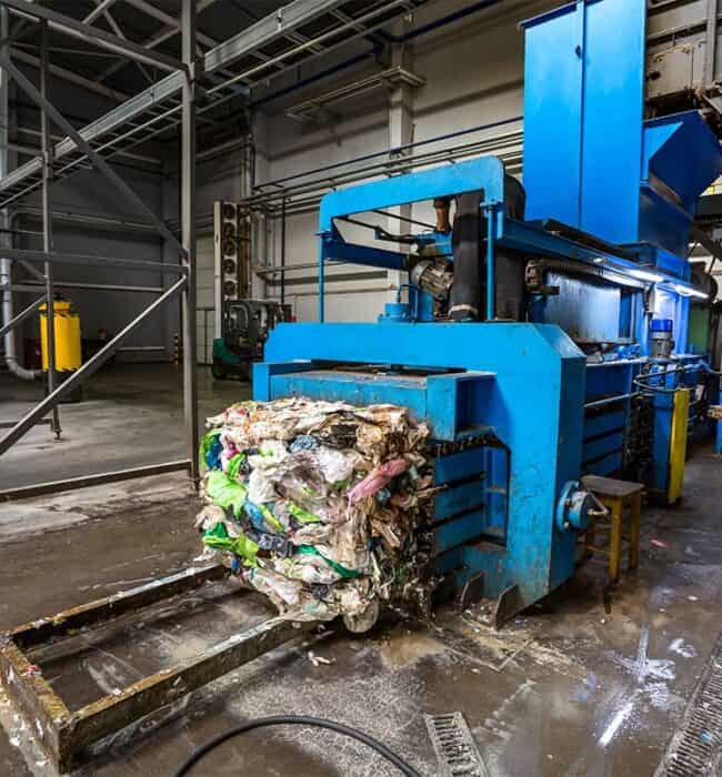 Recycling paper and cardboard using industrial shredding equipment at a waste management facility.