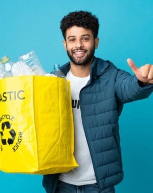 Recycling enthusiast holding a yellow bag filled with plastic bottles, promoting eco-friendly waste disposal.