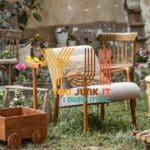 Vintage outdoor garden furniture and decor with wooden planters, chairs, and a barrel table, suitable for junk removal and disposal.