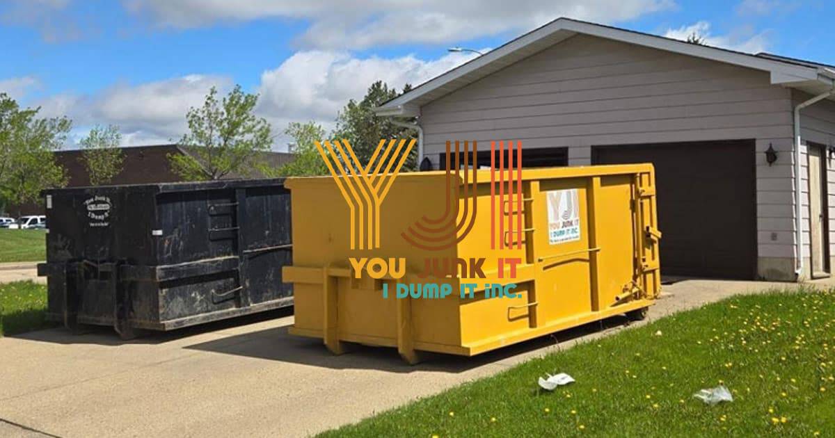 Recycling dumpsters outside a residential garage for junk removal services.