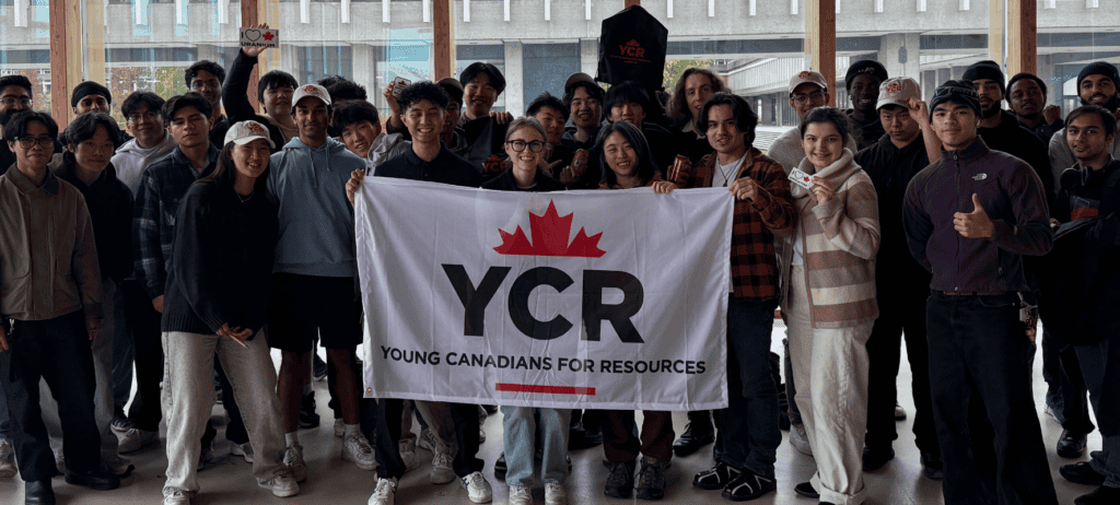 Group of young adults holding a YCR banner on campus, representing Young Canadians for Resources, during an outdoor event.