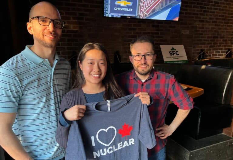 Young Canadians for Resources group supporting nuclear energy, holding a T-shirt with "I ❤️ Nuclear" message.