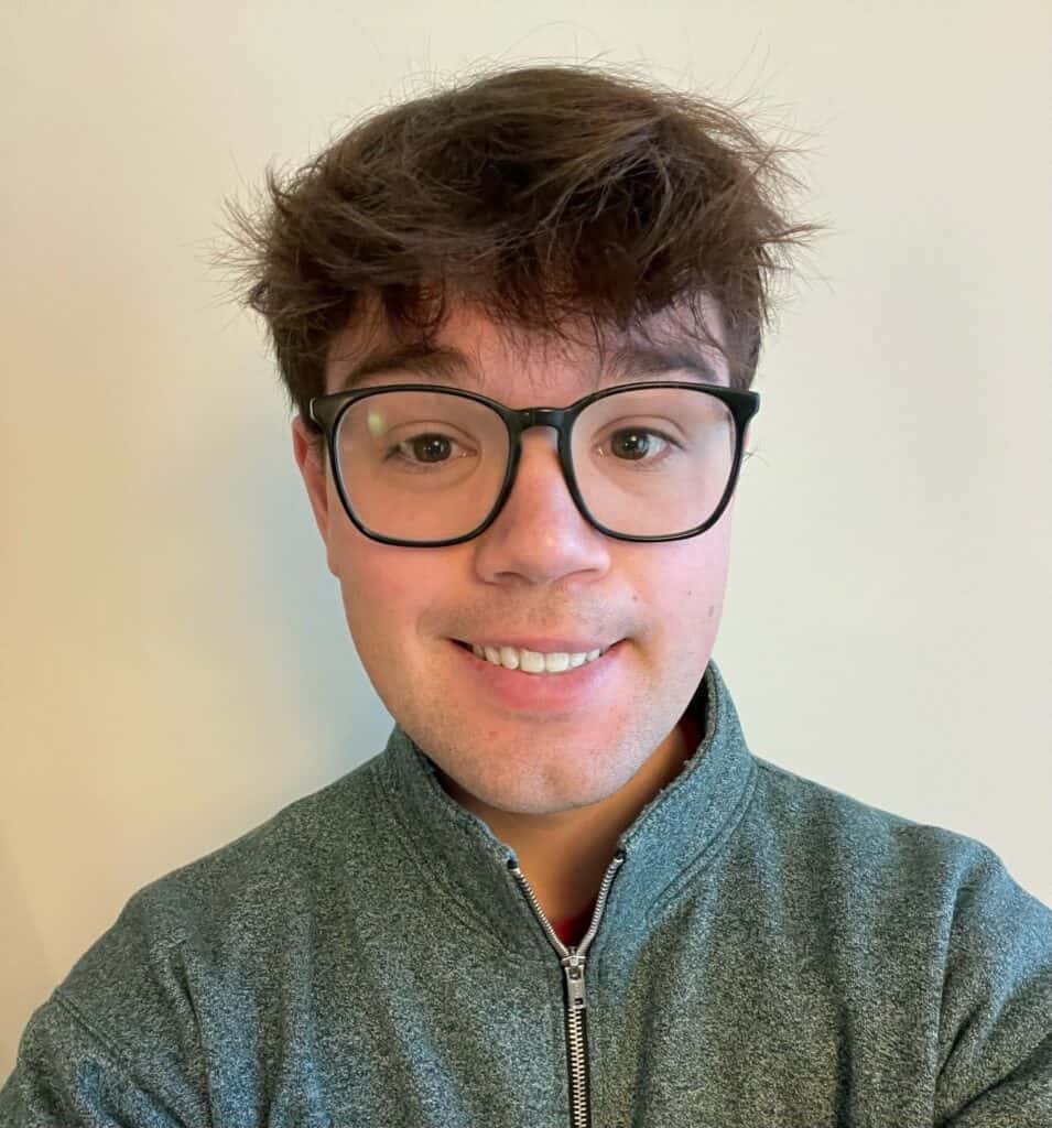 Young man wearing glasses smiling in a portrait for Young Canadians For Resources (YCR) website.