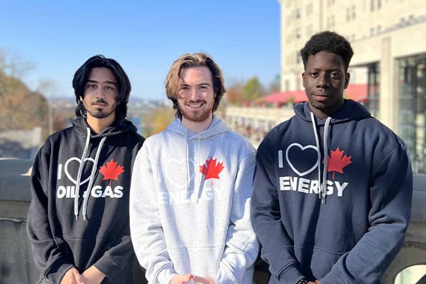 Young Canadians for Resources youth volunteers wearing hoodies with energy-themed slogans outdoors in Vancouver.
