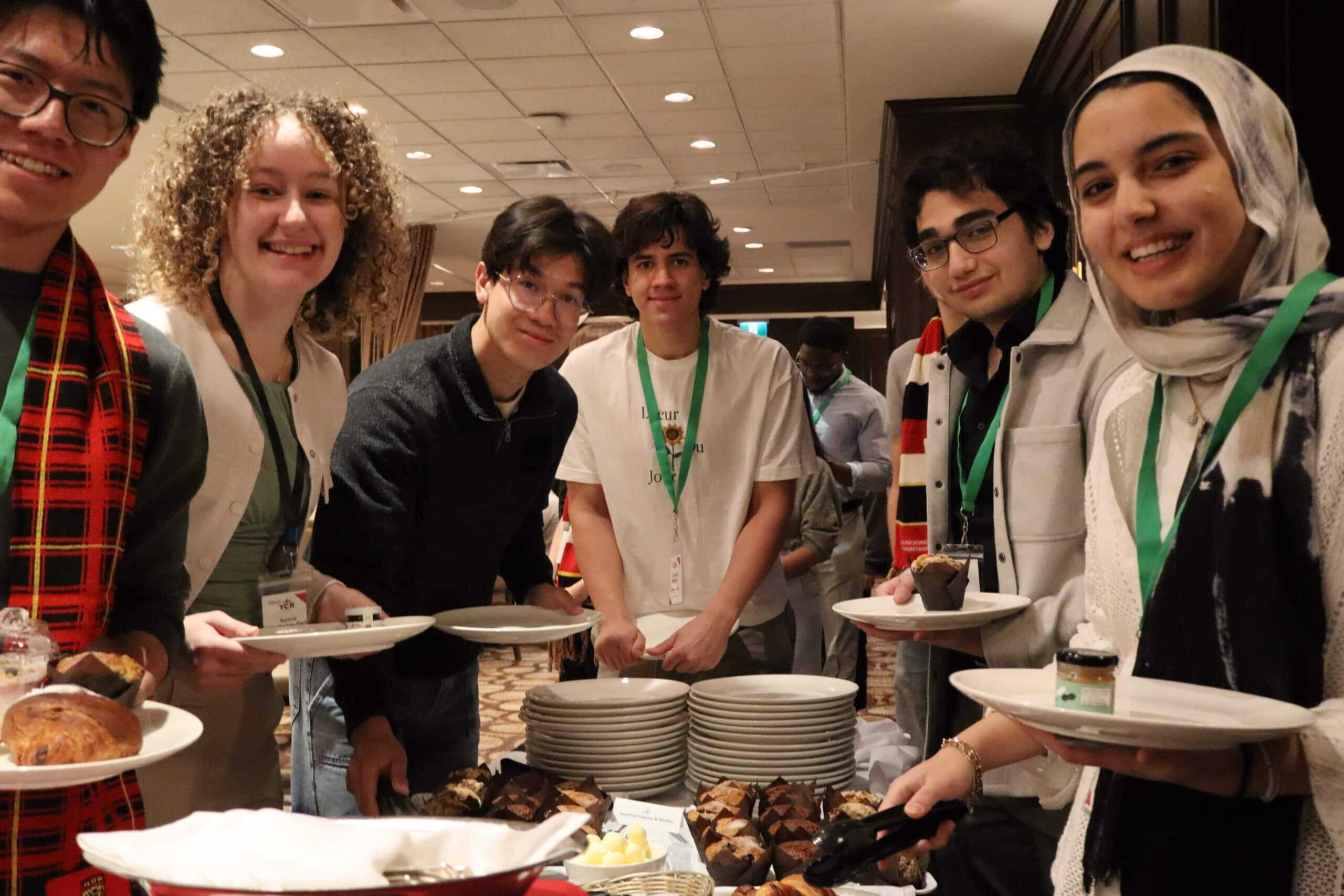 Young diverse youth group at Young Canadians For Resources event enjoying food and networking.