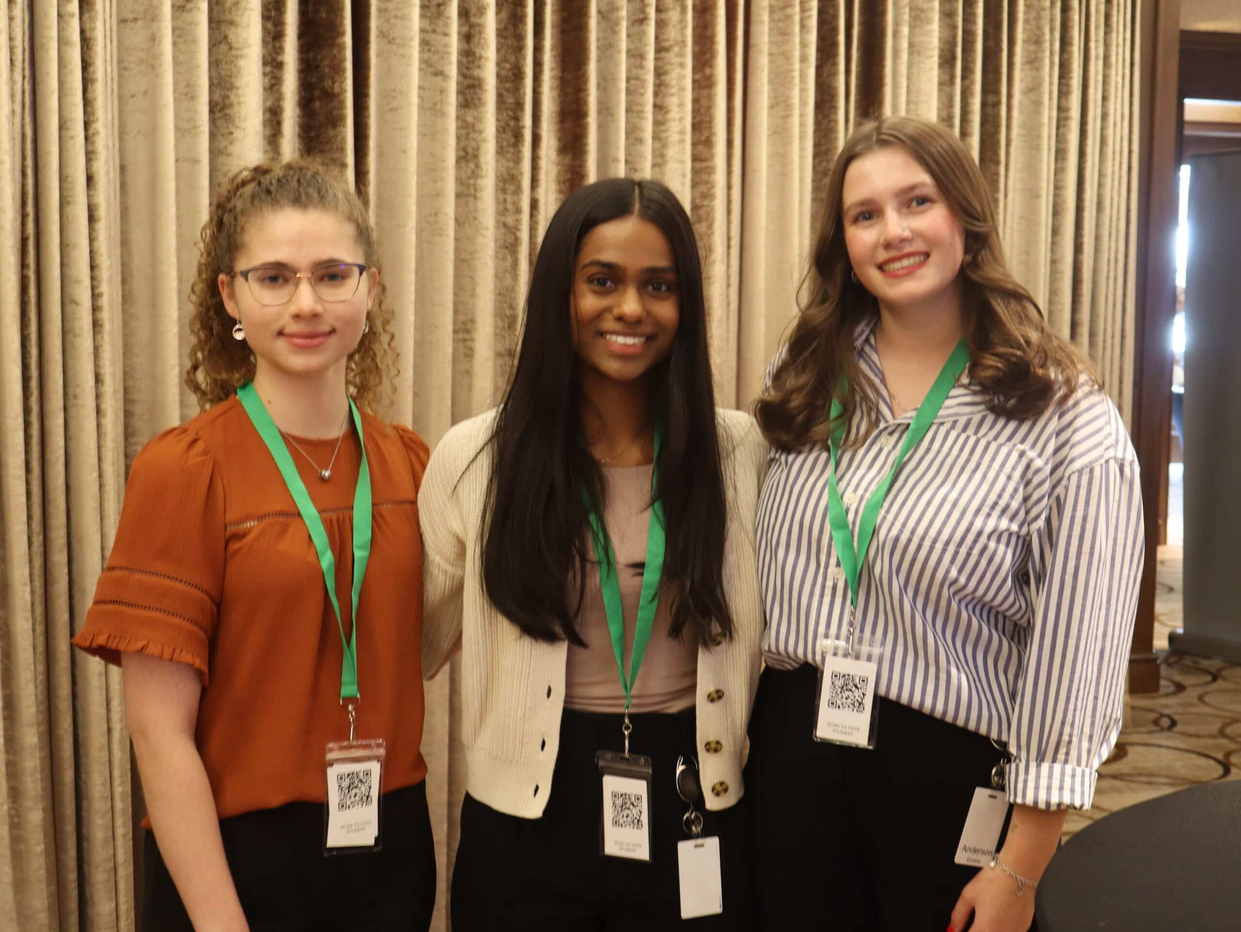 Young Canadian women at an environmental conference, promoting resources and sustainability initiatives.