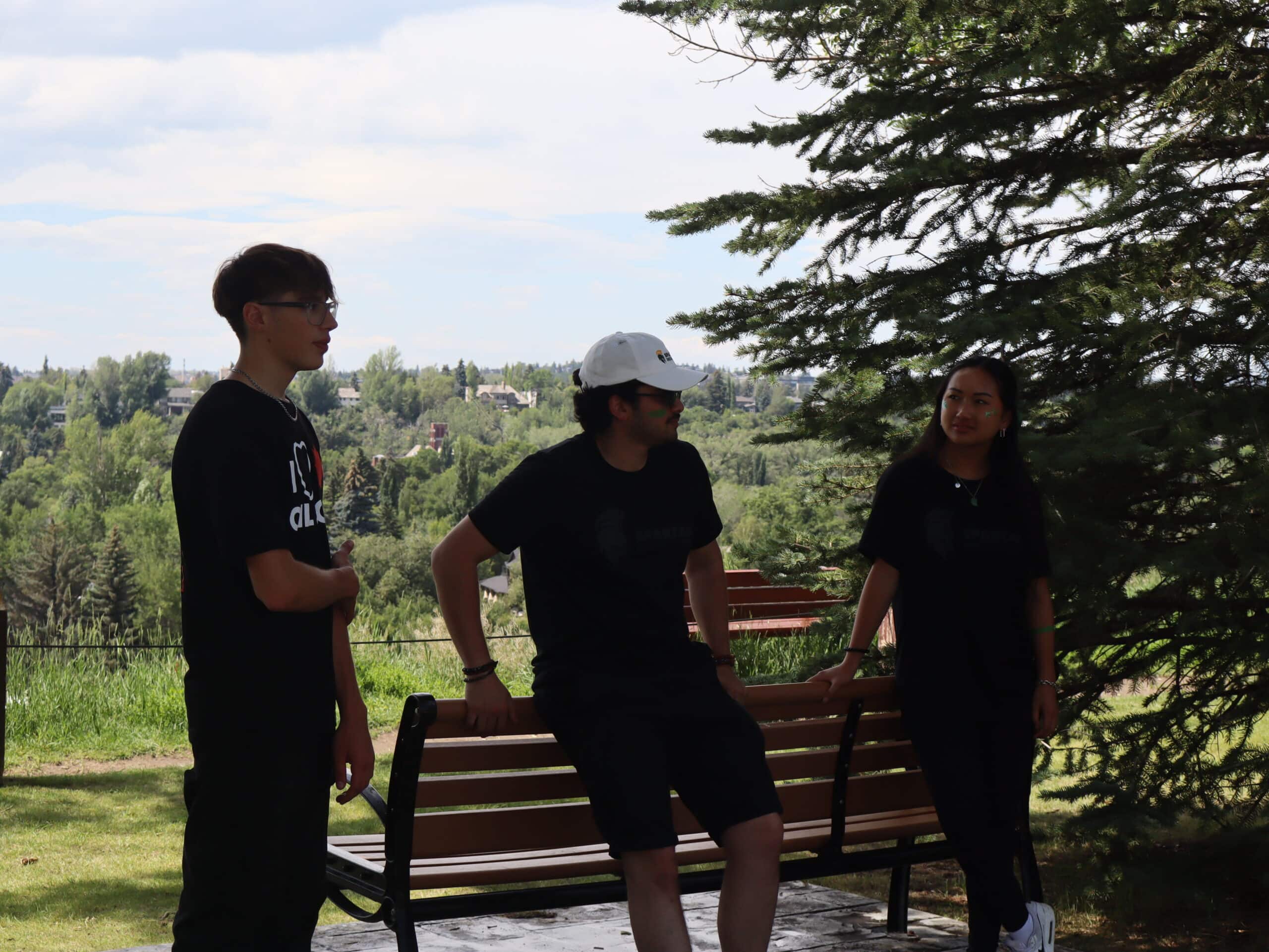 Young Canadians For Resources group discussion outdoors in a park with lush greenery, promoting resource development awareness.