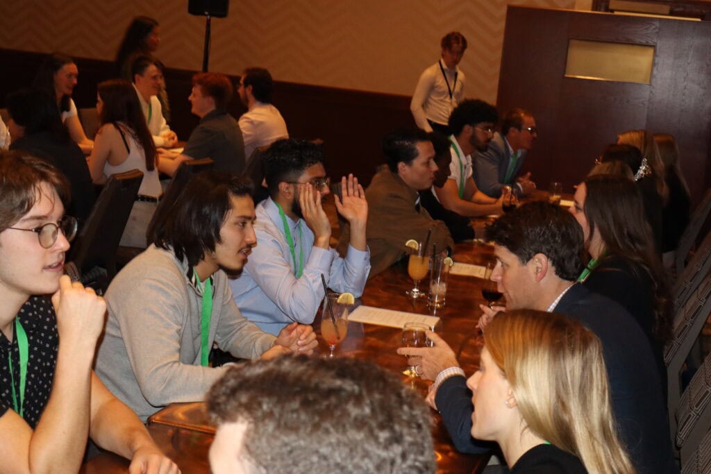Young Canadian professionals at a resource industry networking event, engaging in discussions and sharing ideas in a formal setting.