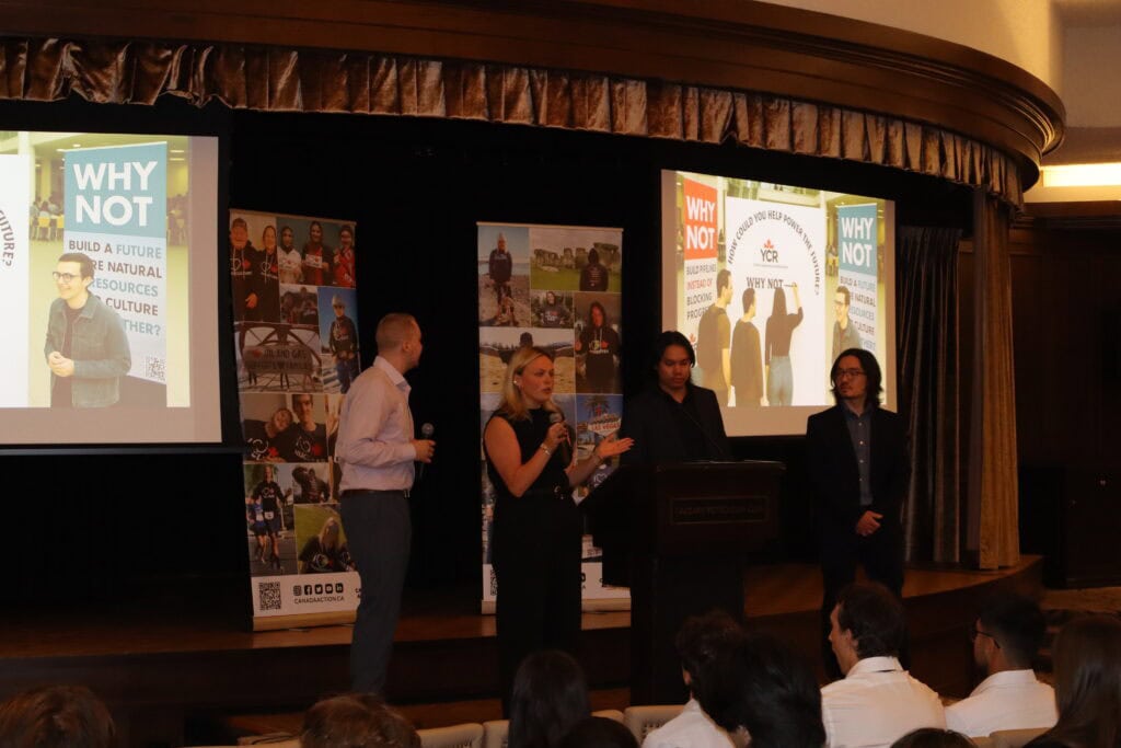 Young Canadians for Resources conference presentation, youth-led discussion on natural resources and energy, with speakers on stage and visual aids highlighting the importance of resource development.