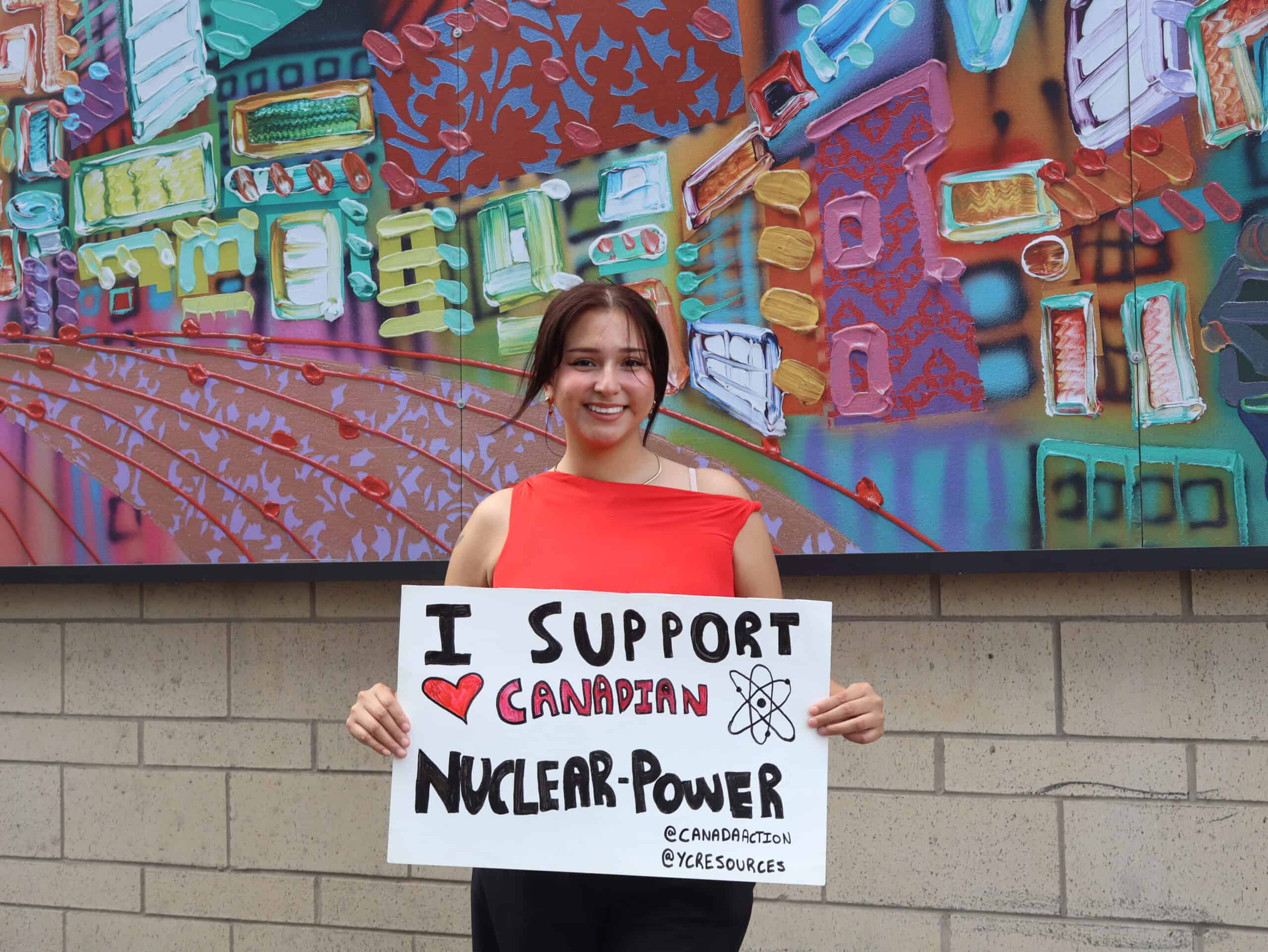 Supporting Canadian nuclear power, young woman holding sign, Young Canadians For Resources, environmental advocacy, clean energy, pro-nuclear, Canada energy future, grassroots activism, environmental conservation, nuclear energy supporters, YCR organization.