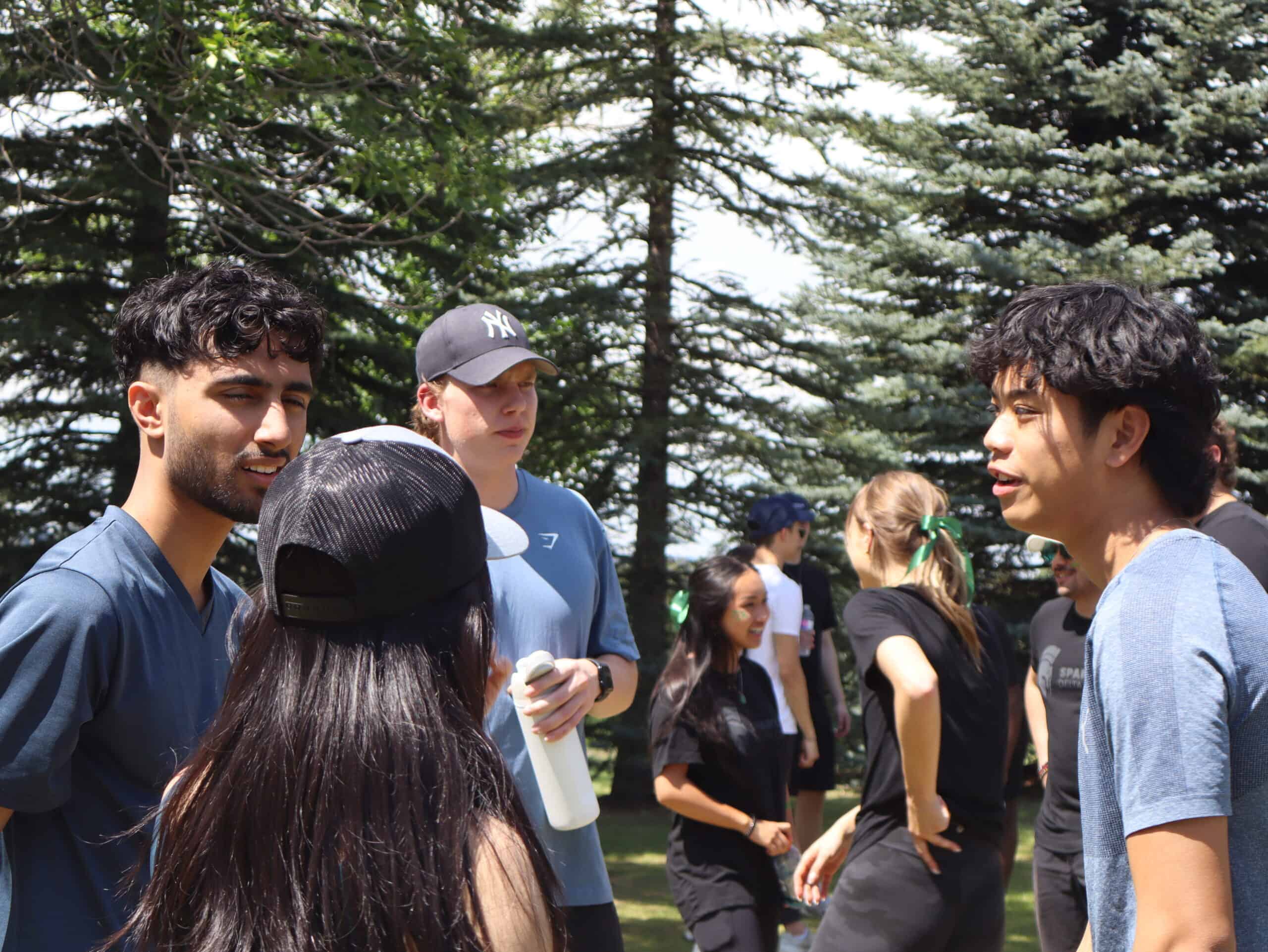 YCR young Canadians for Resources outdoor gathering with diverse young people engaging in conversation at a park on a sunny day.