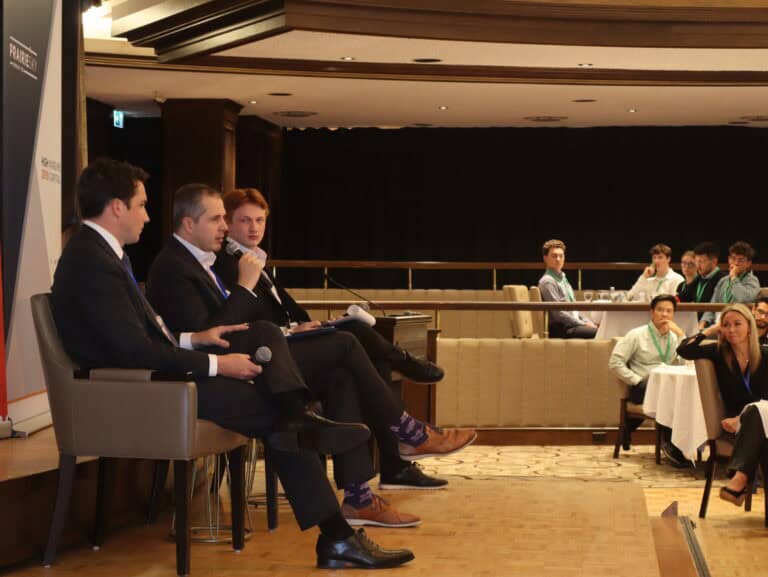 Young Canadians for Resources (YCR) panel discussion at a conference, with four panelists speaking into microphones and an audience of young professionals listening attentively in a formal setting.