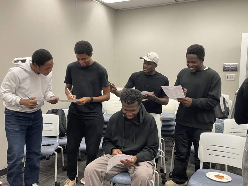 Group of young people reading and discussing in a classroom setting, emphasizing awareness about food waste and energy conservation.