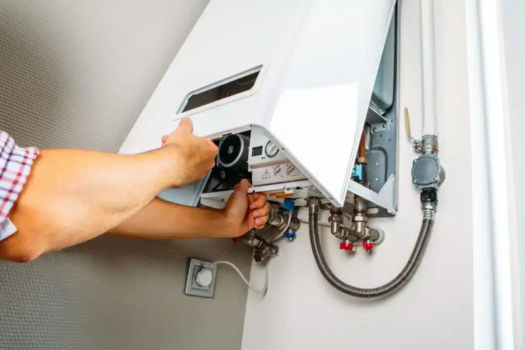 Technician servicing a wall-mounted gas hot water system in a residential property.
