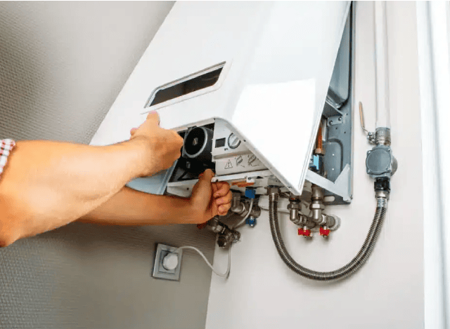Person servicing a hot water unit.