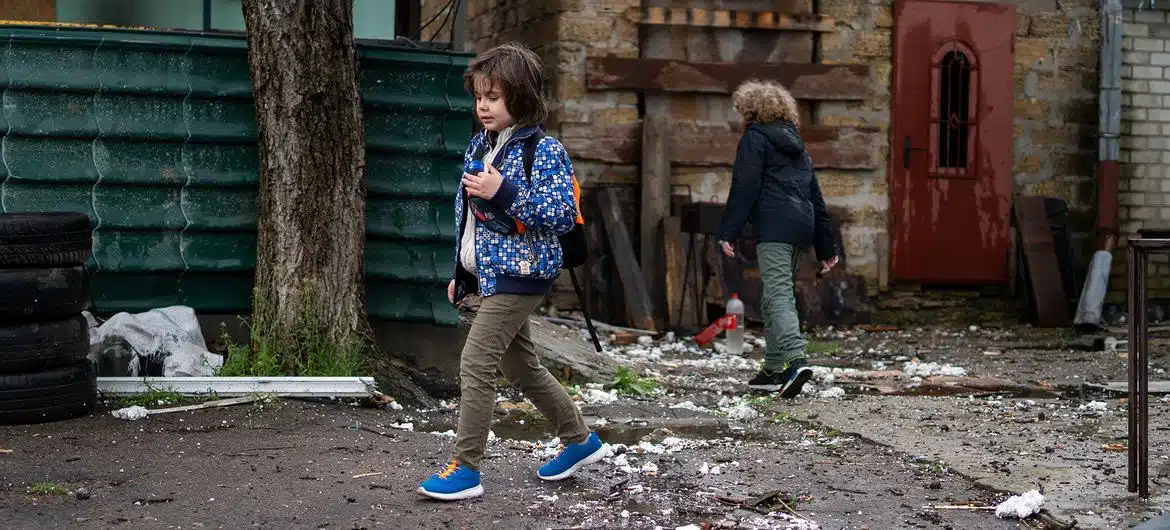 Unos niños caminando junto a una casa destruida en Kherson, Ucrania.