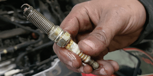 Spark plug being replaced in a vehicle engine for optimal performance.
