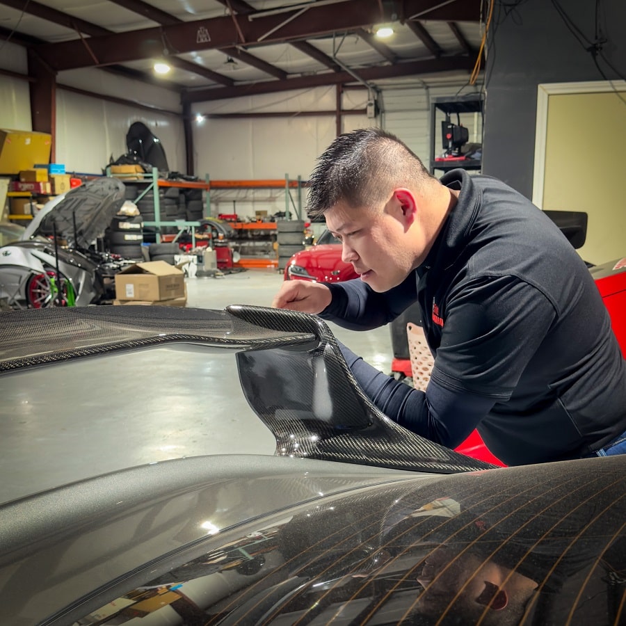 Technician working on a high-performance car in a professional auto shop.