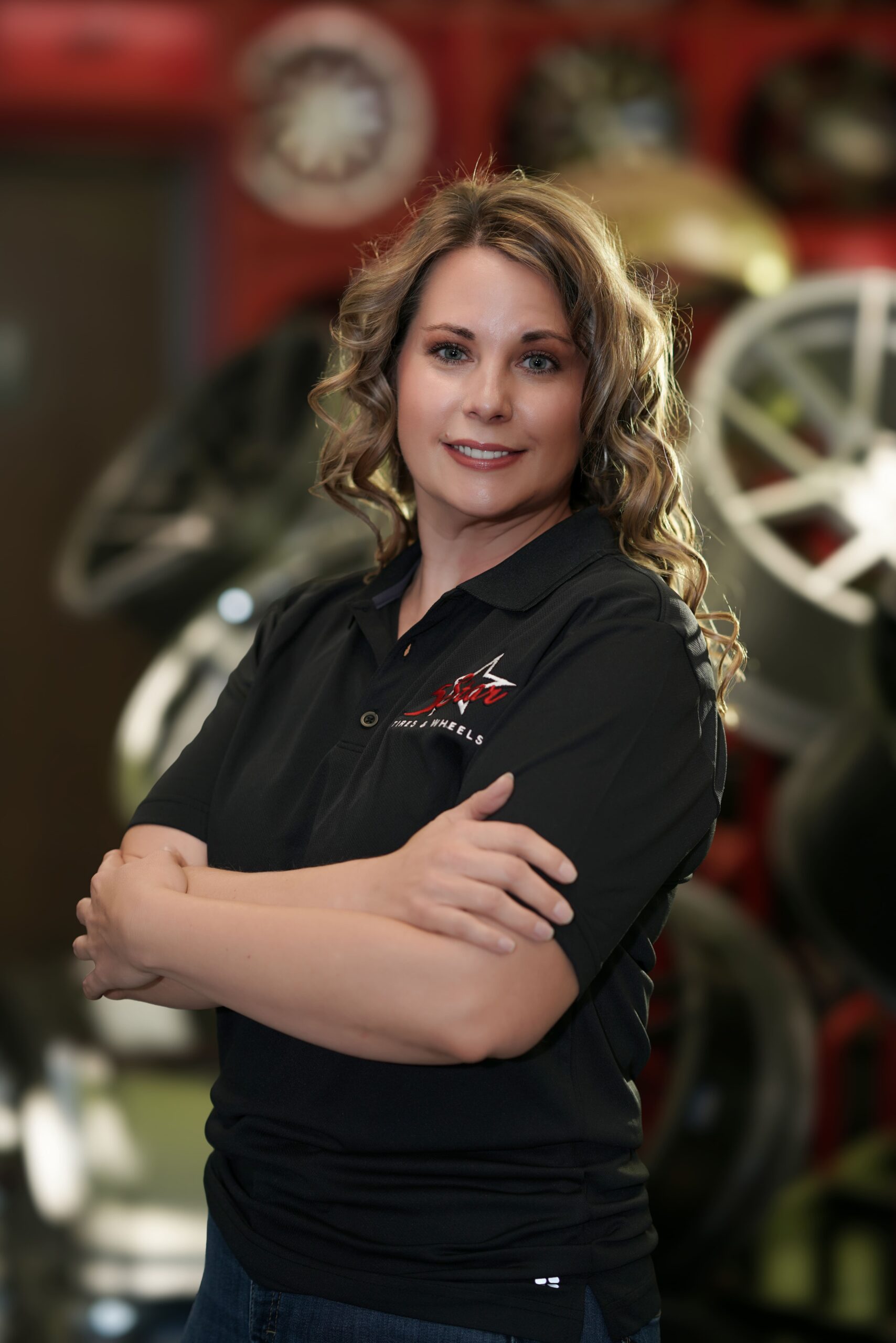 Confident female tire specialist at 5 Star Tires and Wheels store.